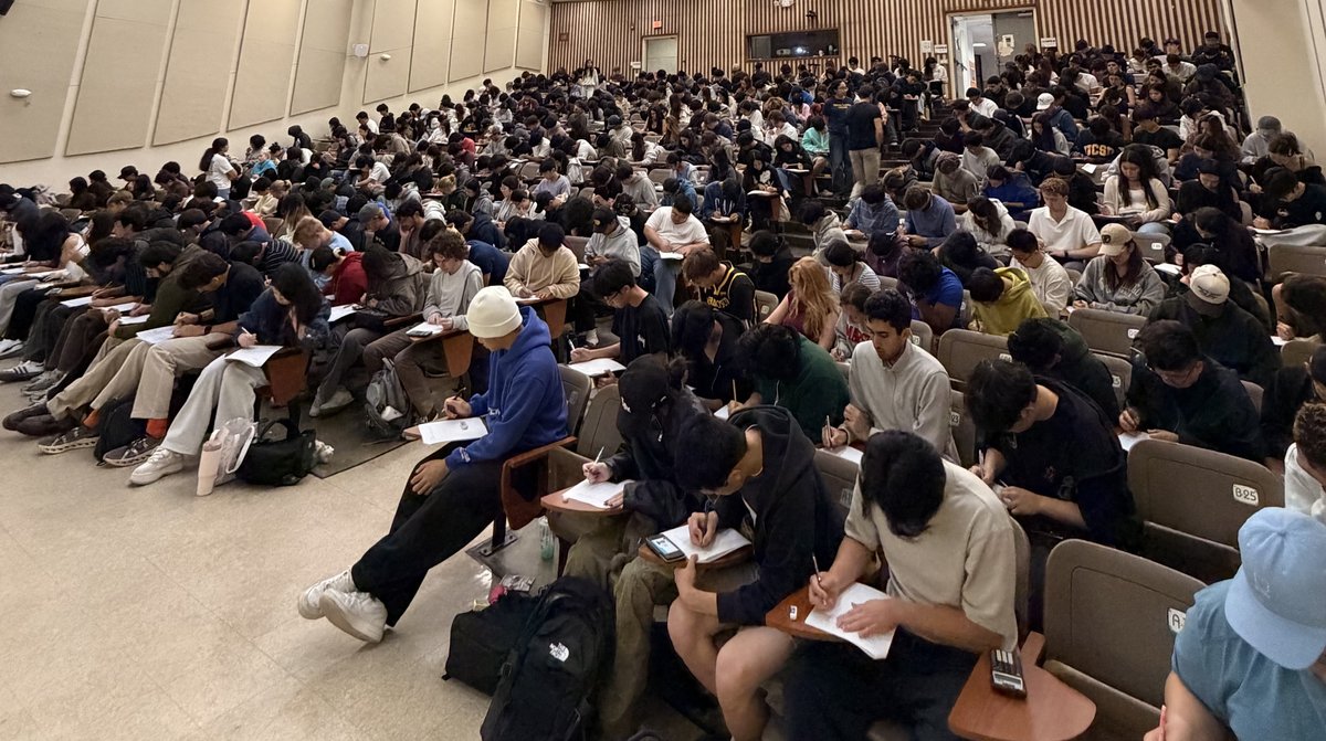 Students during an exam in a large lecture hall